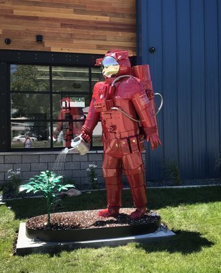 Hunter Brown; Pioneer, 2020, Original Sculpture Steel, 48 x 120 inches. Artwork description: 241 Pioneer is a large stainless steel sculpture constructed from stainless steel with a red powder- coat finish. This 10  astronaut is mounted to a reservoir base which circulates water through his body to watering can, that waters a metal marijuana plant. The reservoir is covered with expanded ...