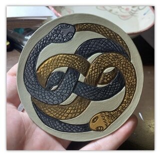 Nicole Calise: 'the neverending story 2 of 6', 2021 Leather, Movies. The NeverEnding Story Leather Coaster Set is comprised of 6 Hand Carved Hand Painted Coasters.  This piece is coaster number 2 in the set - The Auryn.  These coasters are 100veg- tan leather.Hand carved and painstakingly hand painted and sealed.  Each coaster features a cork backing and is burnished with ...