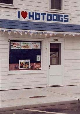 Ruth Zachary: 'America Eats', 1994 Color Photograph, Americana. American store front delicatessen featuring hot dogs! Great graphic shapes, style and humor. Bright red, white and blue colors with American flag streamer detail. I have it hanging in my kitchen. Always gets a smile. And, who doesnt	love a hot dog? ! Greenport, Long Island. Signed and titled. 8 x ...